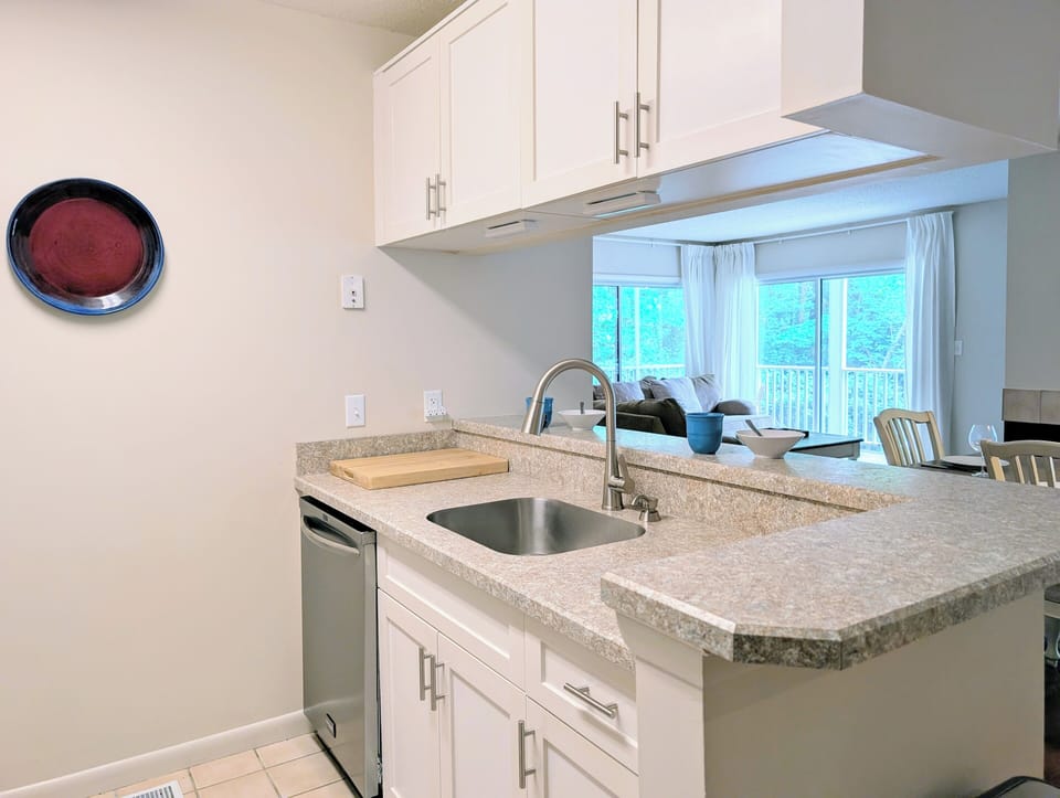 Functional Kitchen Design - Every inch of this kitchen is optimized for efficiency, boasting plenty of cabinet storage and a practical U-shaped layout. It’s a bright, functional workspace that makes beach-house meal prep a total pleasure.
