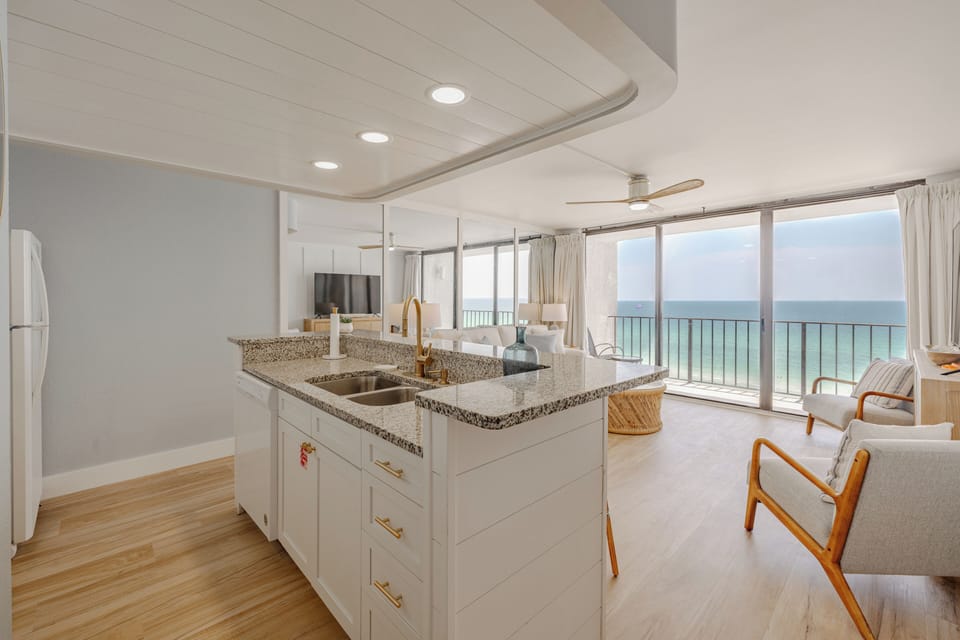 Modern kitchen island with ocean views through floor-to-ceiling windows