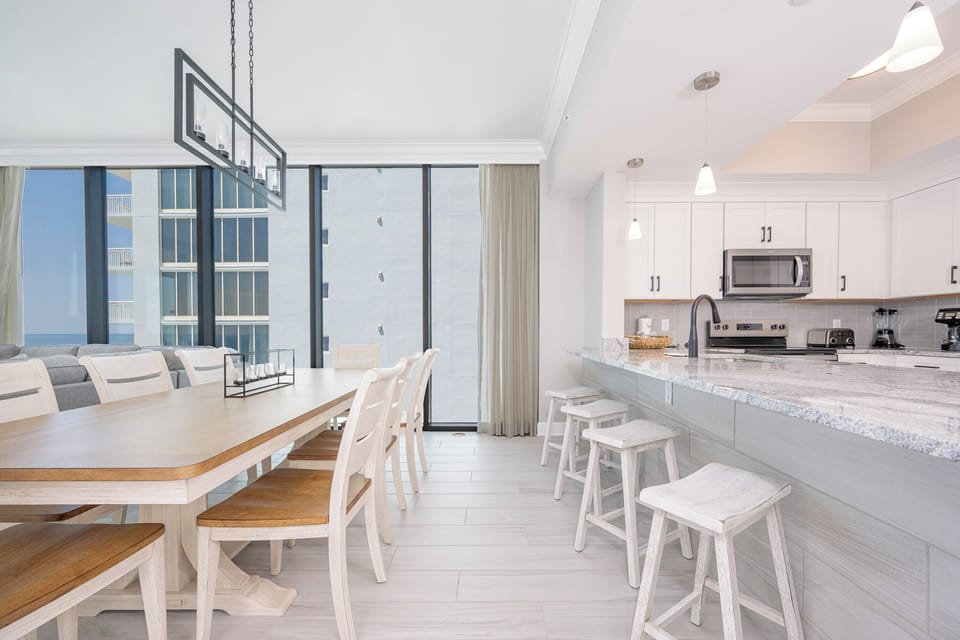 Gather around the dining table or breakfast bar to enjoy meals with a beachfront view