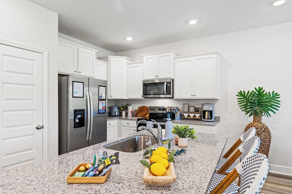 Sleek modern kitchen with white cabinetry, stainless steel appliances