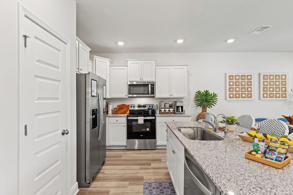 Sleek modern kitchen with white cabinetry, stainless steel appliances
