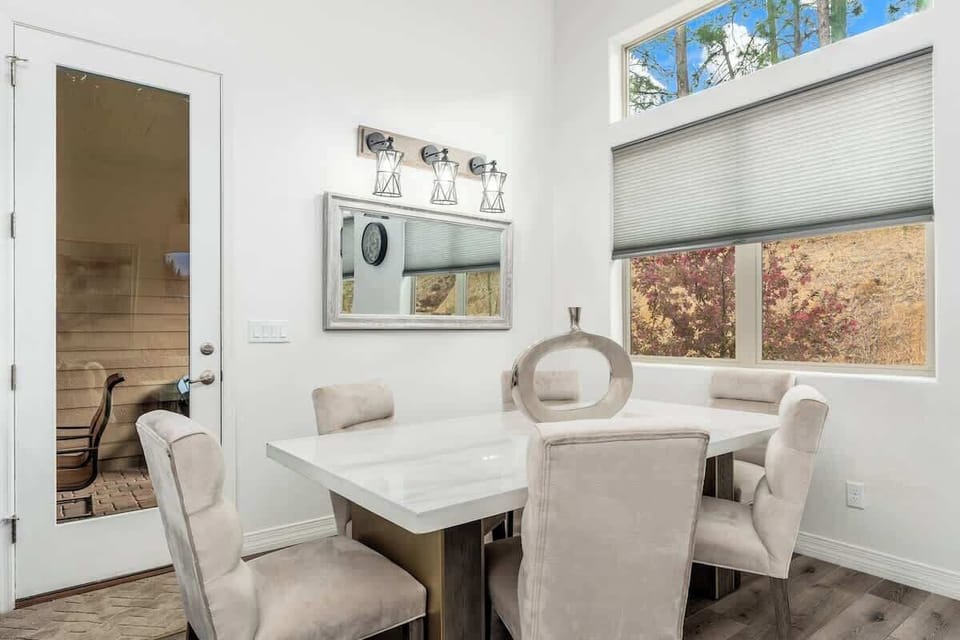 Step through to your private sauna, where warm wood and soothing heat invite you to unwind. Inside, gather around the elegant dining table with plush seating and natural light streaming through the windows.