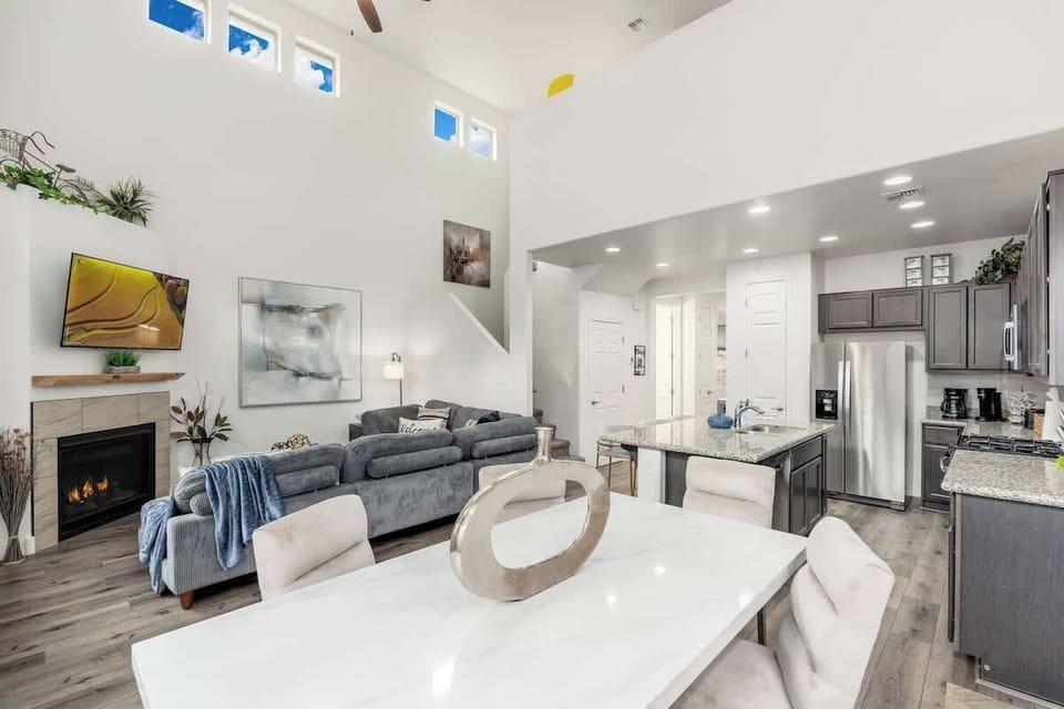 Your open-concept haven features soaring ceilings, skylights flooding the space with natural light, a cozy fireplace, and a fully equipped modern kitchen—perfect for relaxing and gathering together.