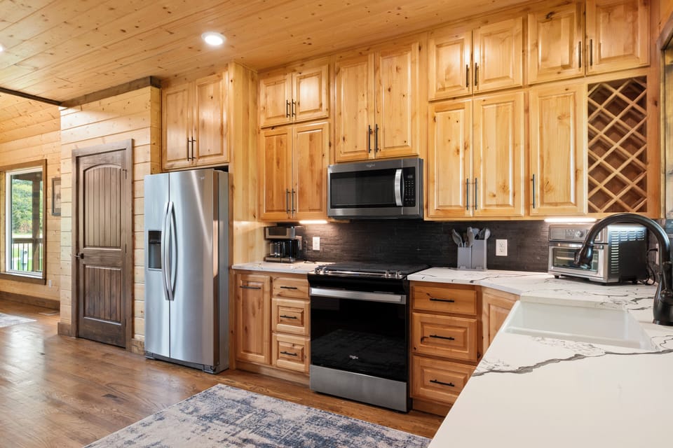 Refrigerator, microwave, range, Keurig/Traditional coffee maker, & farm sink.