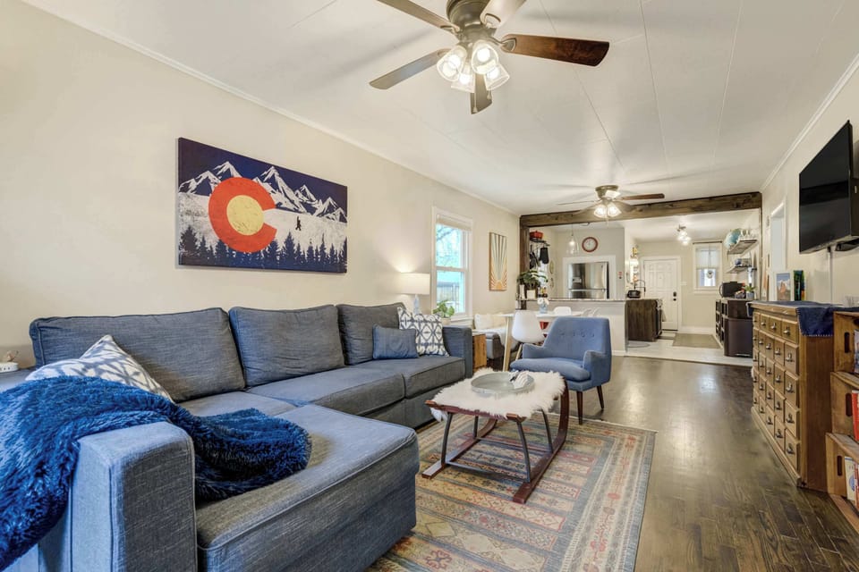 Unwind in the cozy living room, complete with a plush sectional, Colorado mountain art, and warm, rustic-modern charm

