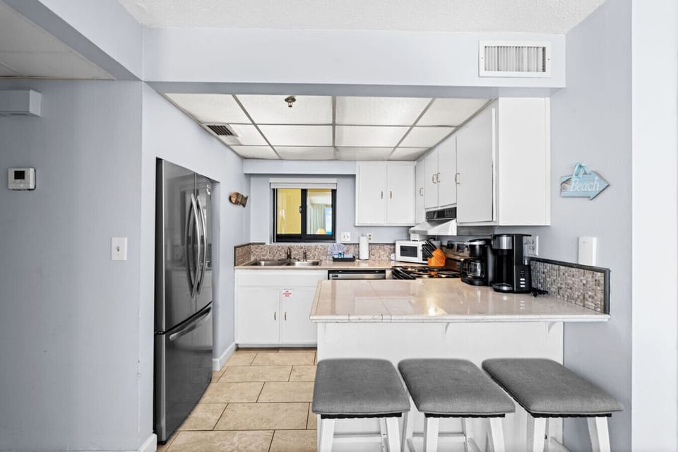 Enjoy a full kitchen with stainless steel appliances and bar seating for three—perfect for casual meals or morning coffee.