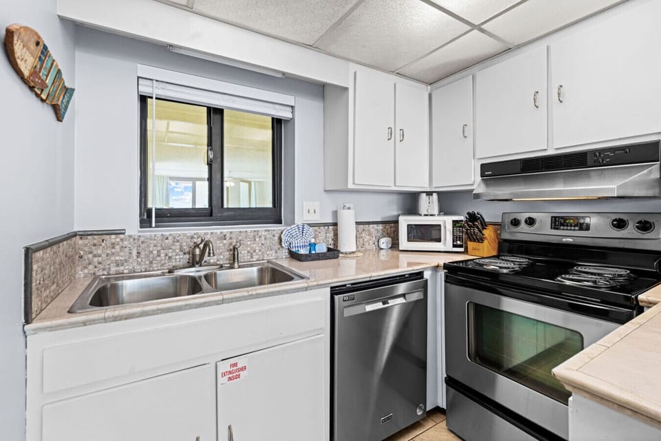 This well-appointed kitchen features a double sink, dishwasher, electric range, and all the essentials for your stay.