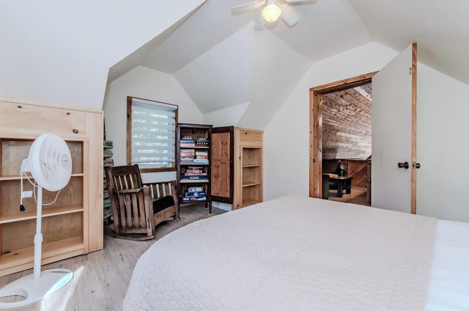 Bedroom 1: Bright and cozy bedroom featuring a reading nook and a library of board games — perfect for a relaxing cottage vacation near the lake!