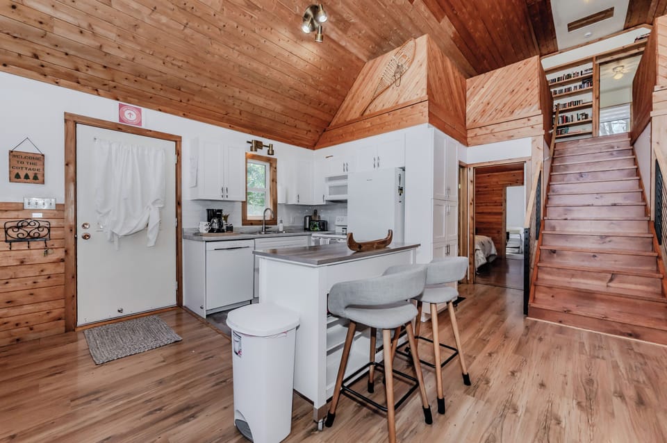 Spacious open-concept kitchen and living area with vaulted ceilings and rustic charm — perfect for cozy family stays at your lakeside getaway!