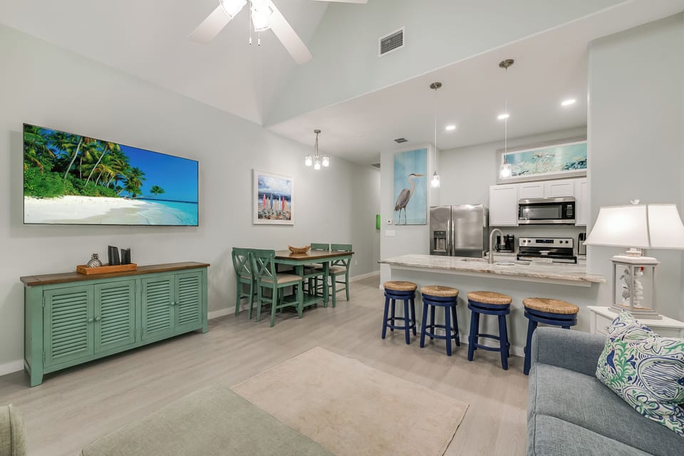 Relax in your open-concept living space where coastal colors and modern amenities blend perfectly for your vacation comfort.