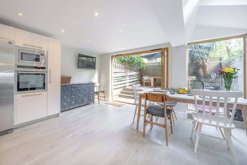 Ground floor - large space with a modern and fully equipped kitchen, a dining area, and a TV. Leads to the terrace at the back of the property