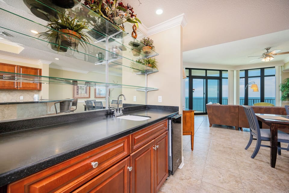 Craft refreshing drinks at this sleek wet bar while enjoying coastal views just beyond the window