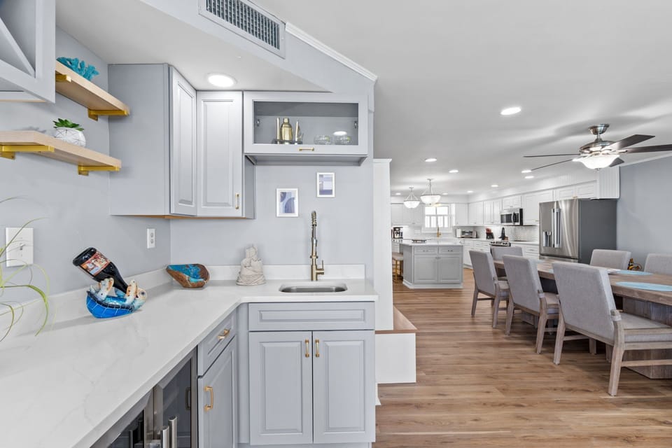 Just off the living room, a sleek coffee bar and built-in wine cooler offer the perfect setup for morning brews and evening pours.