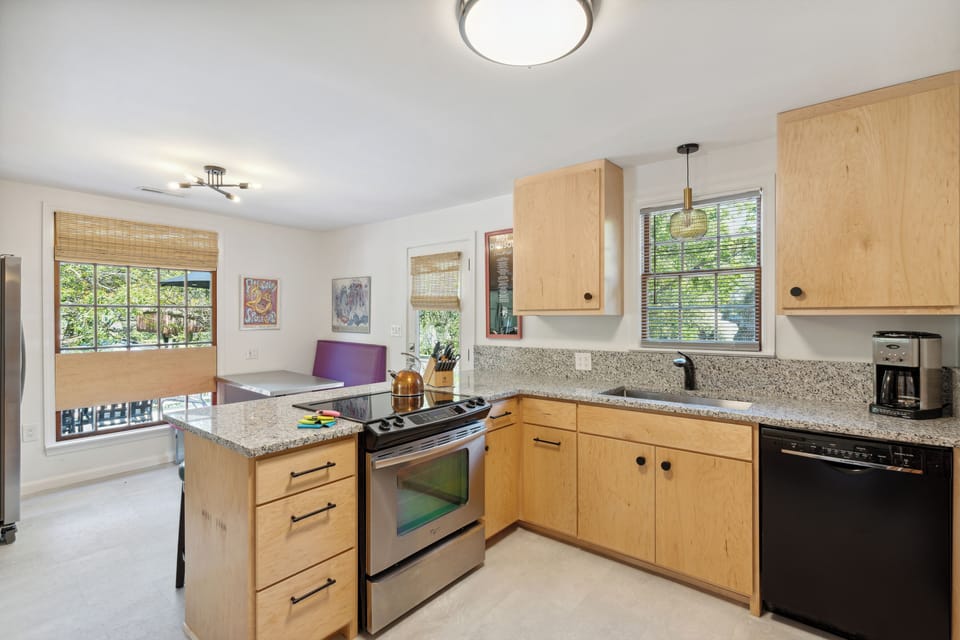 Full kitchen and modern appliances with a breakfast bar and dining area.