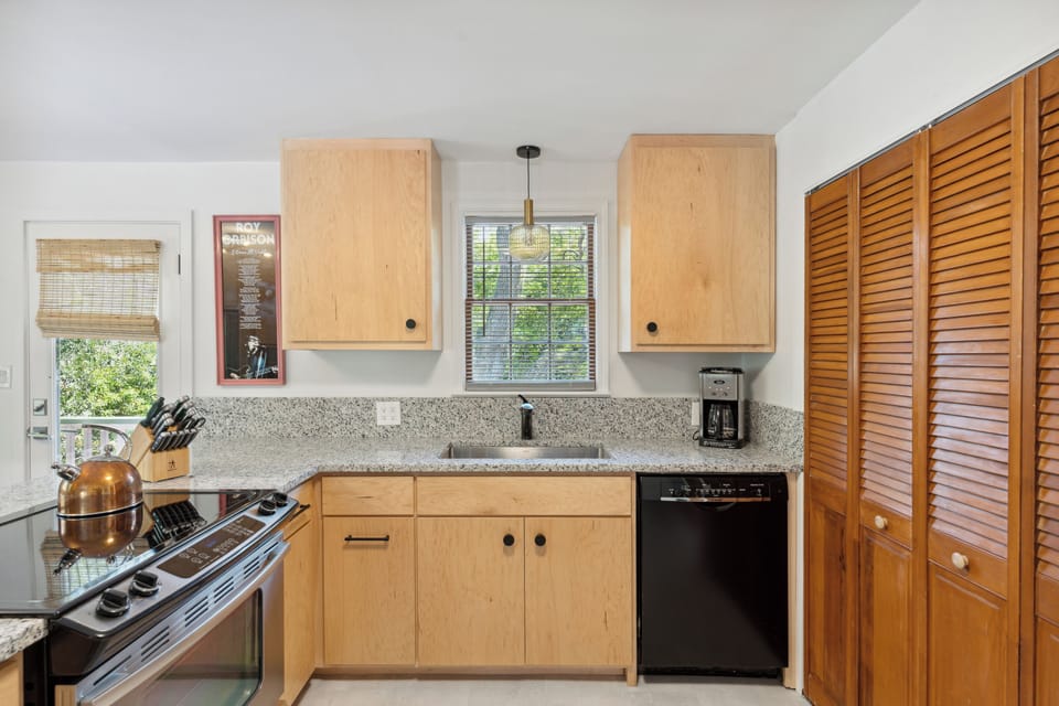 Full kitchen and modern appliances with a breakfast bar and dining area.