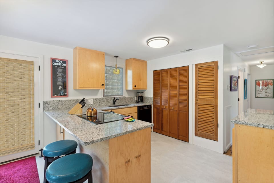 Full kitchen and modern appliances with a breakfast bar and dining area.