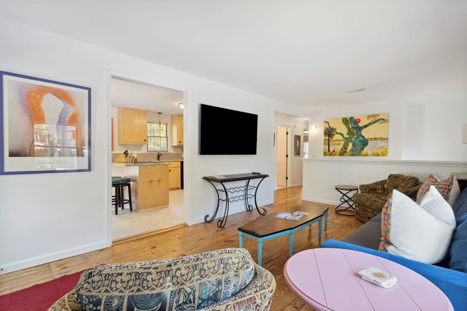 The open living room with multiple comfortable seating areas and large TV.