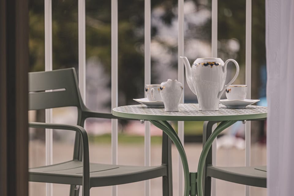 Morning coffee outdoors – start your day in a seaside apartment with a view of greenery and the path to the beach.
