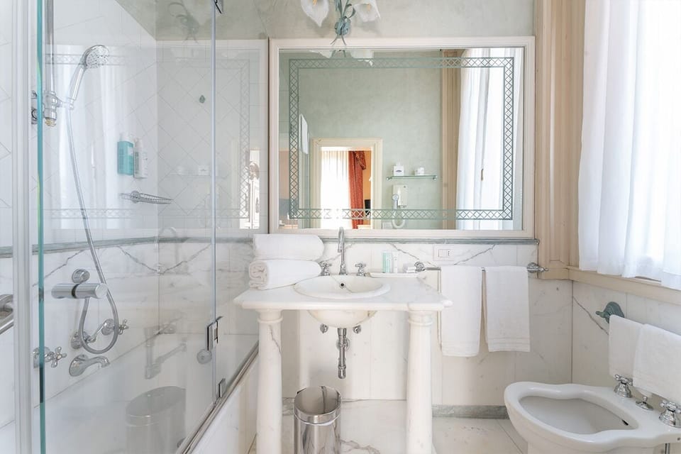 Deluxe Room | Bathroom | Hair dryer, slippers, bidet, towels