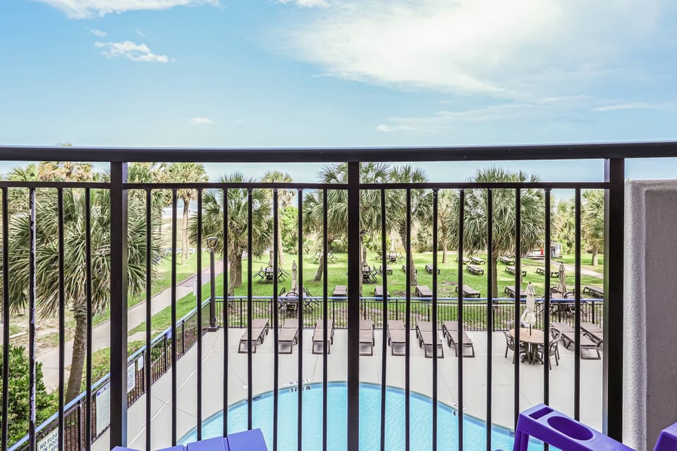 Sip your morning coffee with this view—lush palms, poolside vibes, and the beach path just steps away. Your private balcony is the front row seat to paradise. 