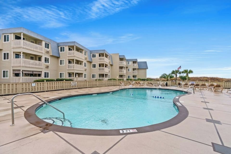Take a cool dip in the sparkling pool after a fun day at the beach.