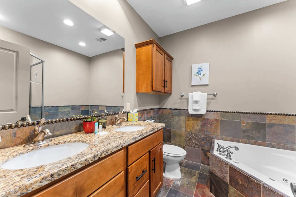 This king ensuite includes a double vanity, shower, & luxurious soaking tub