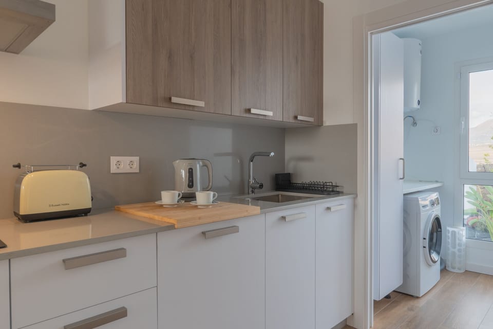 Fully equipped independent kitchen in wood and grey tones.