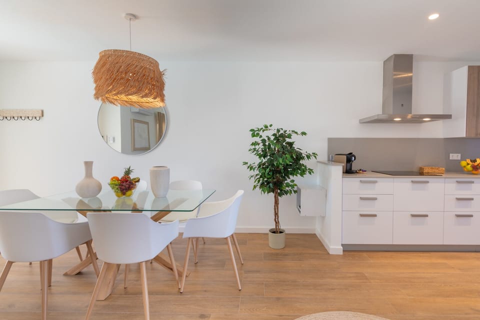 Bright indoor dining room with glass table and designer chairs.