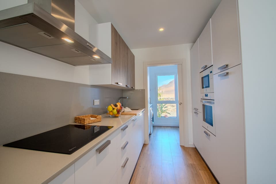 Fully equipped modern white and wood kitchen.