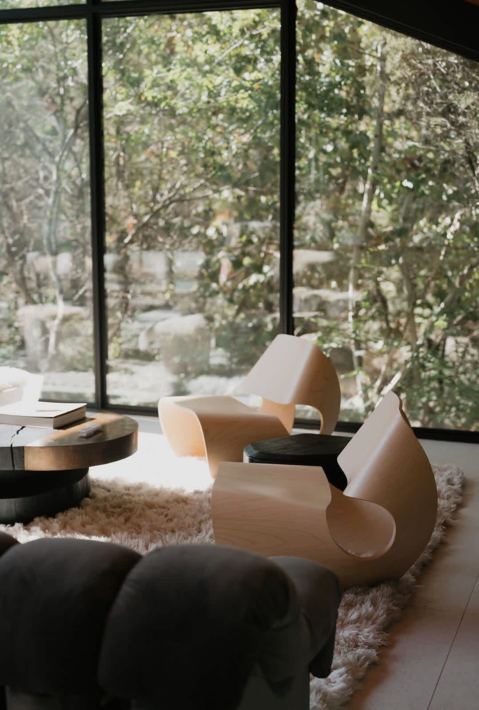 Sculptural seating bathed in natural light creates a moment of stillness and reflection. Thoughtful design meets the serenity of the surrounding forest for a sense of effortless calm.