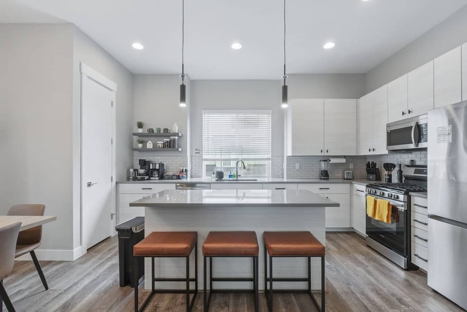 Whip up your favorites in a fully equipped modern kitchen with stainless steel appliances, a spacious island, and a cozy coffee bar.