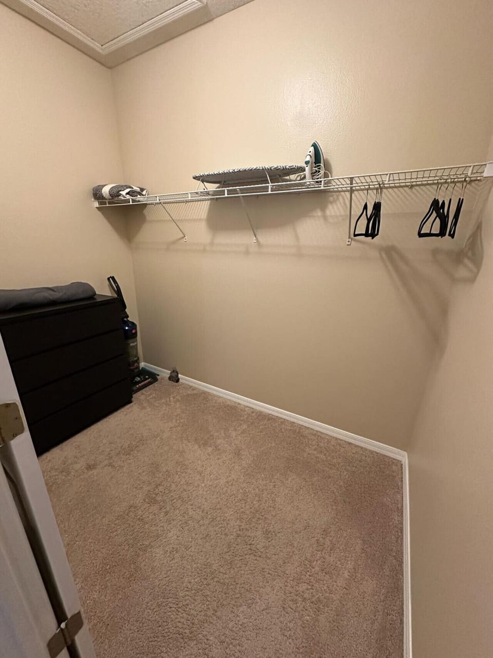 Spacious walk-in closet with iron and hangers.