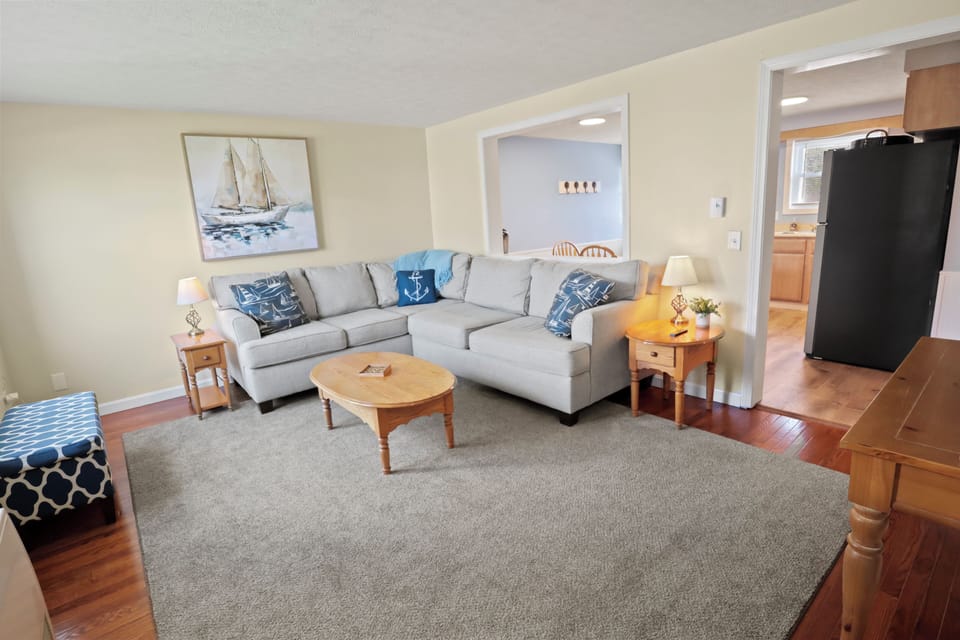 Coastal-style living room with comfy seating and 65" smart TV for streaming.