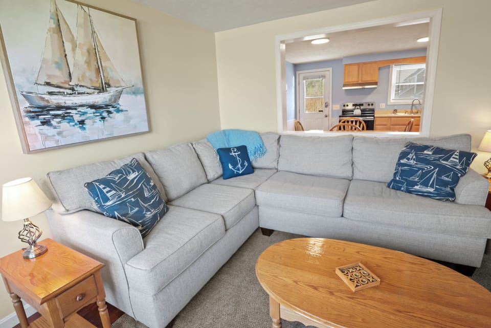 Coastal-style living room with comfy seating and 65" smart TV for streaming.