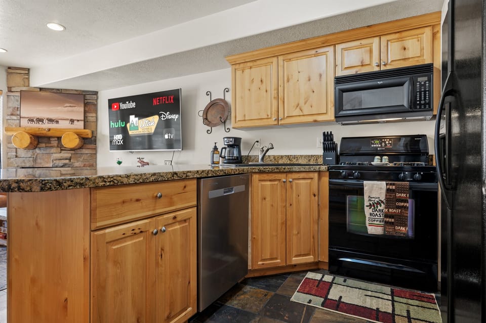 Gourmet kitchen with gas stove, fridge with ice maker, and dishwasher.