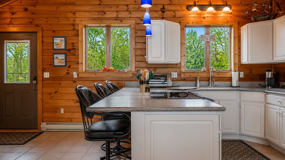 Enjoy a spacious and modern kitchen with sleek black bar stools, perfect for casual dining and socializing.
