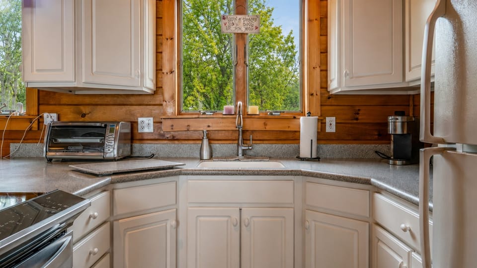 Cozy kitchen with modern appliances and scenic views, perfect for cooking and relaxing.