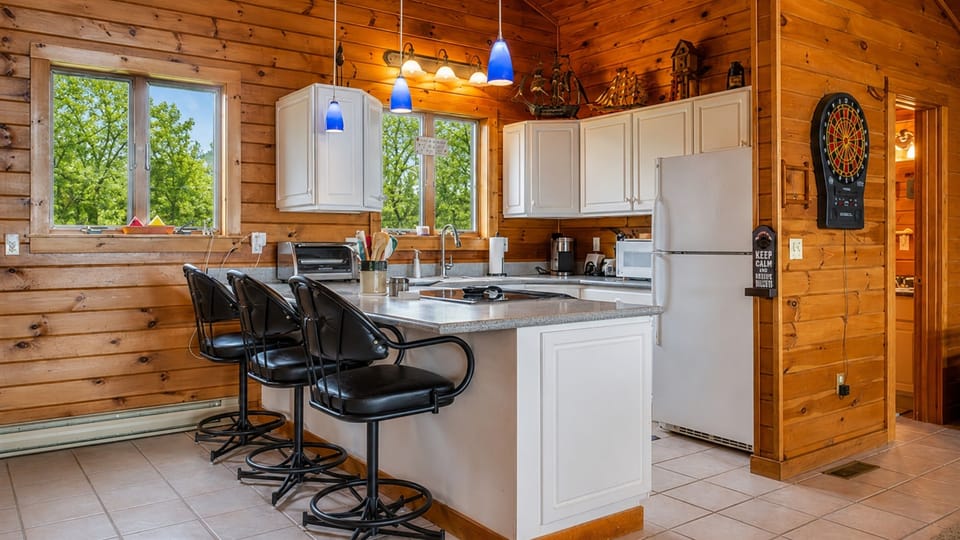 Enjoy a spacious and modern kitchen with sleek black bar stools, perfect for casual dining and socializing.