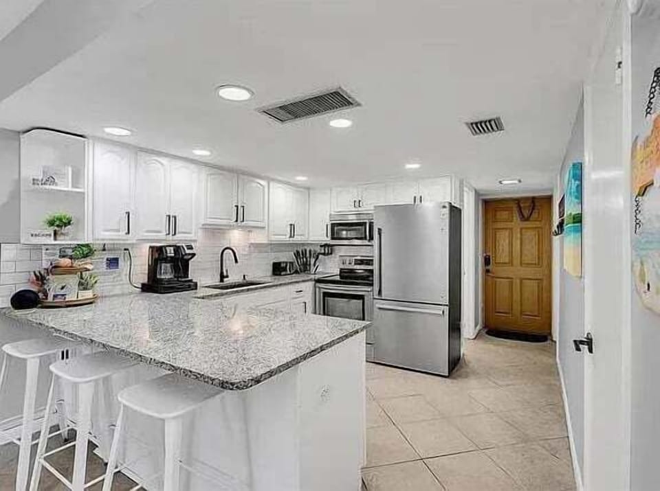 Modern and bright with stainless steel appliances, granite counters, and breakfast bar seating.