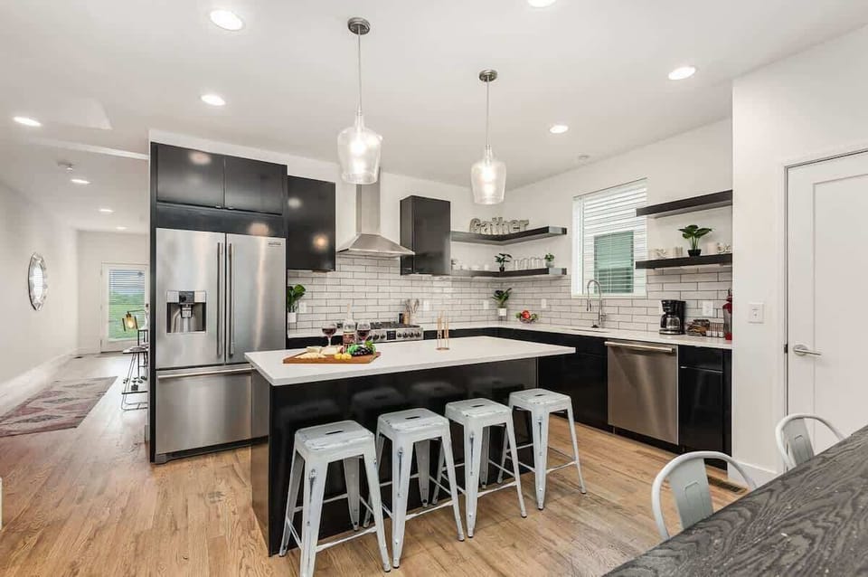 Fully Equipped Kitchen with stainless steal appliances, bar seating, and a dining area.