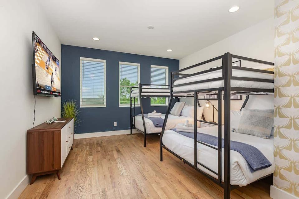 Unit 1: Additional Sleeping Arrangement featuring 2 Twin over Full Bunk Beds, Smart TV, Dresser, and Futon.