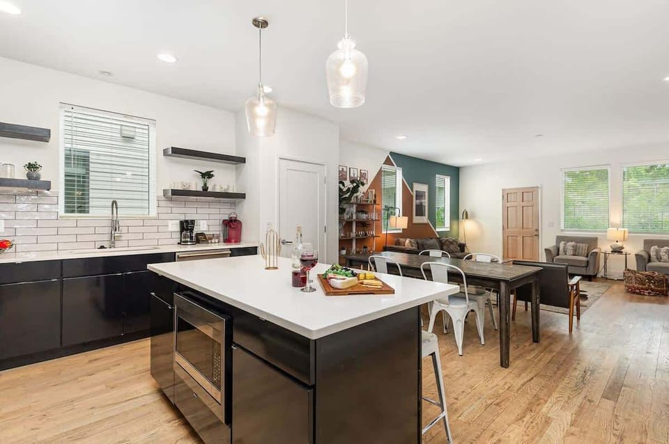 Unit 1: Fully Equipped Kitchen with stainless steal appliances, bar seating, and a dining area.