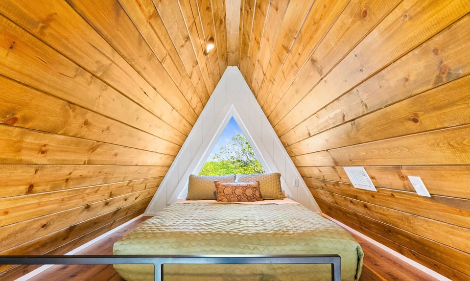 With its warm wood walls and triangular window, the loft’s queen nook feels like a dreamy A-frame hideout.