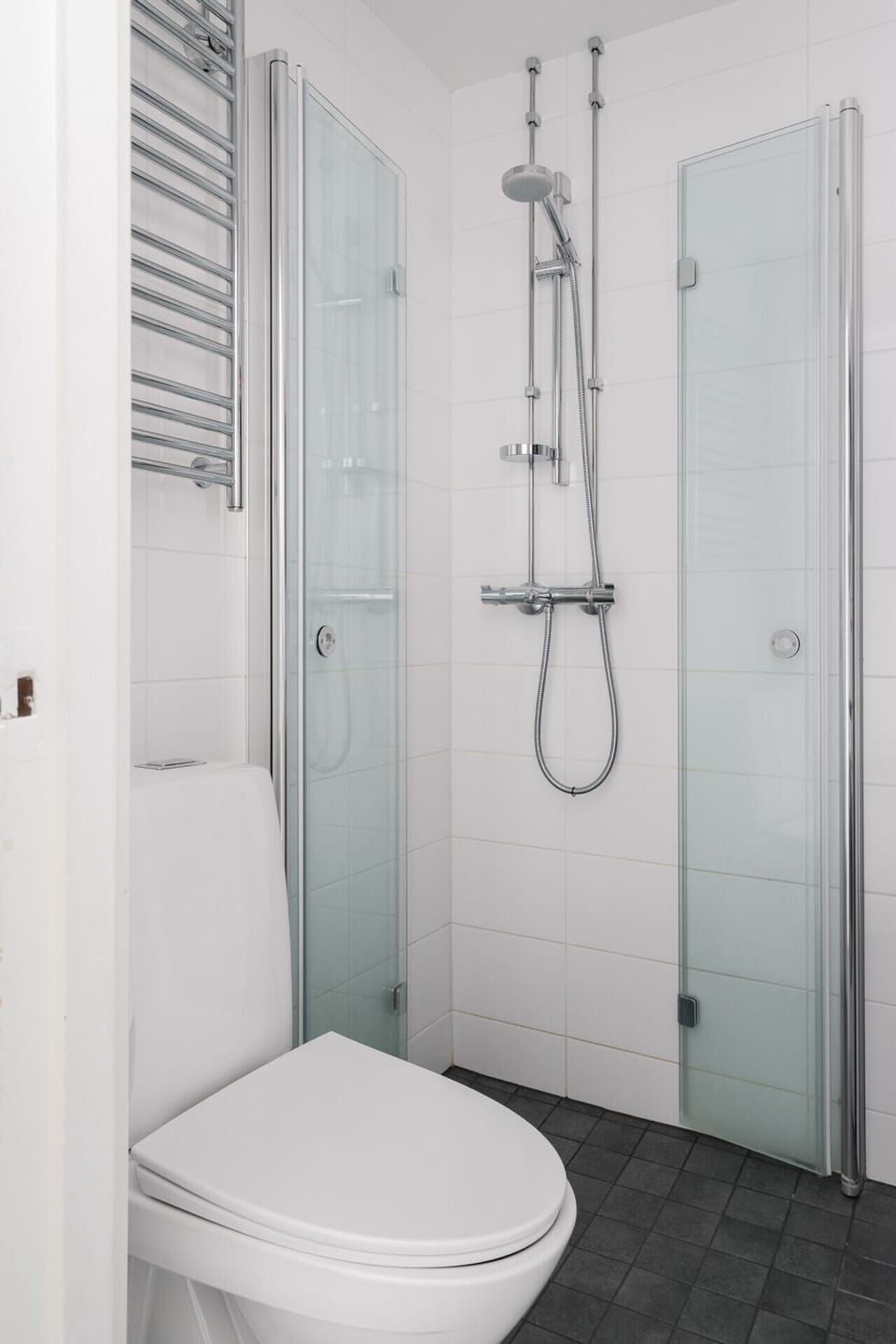 The bathroom features a sleek, adjustable shower, allowing you to set the perfect water pressure and temperature for ultimate relaxation. Enjoy a refreshing, personalized shower experience every time.