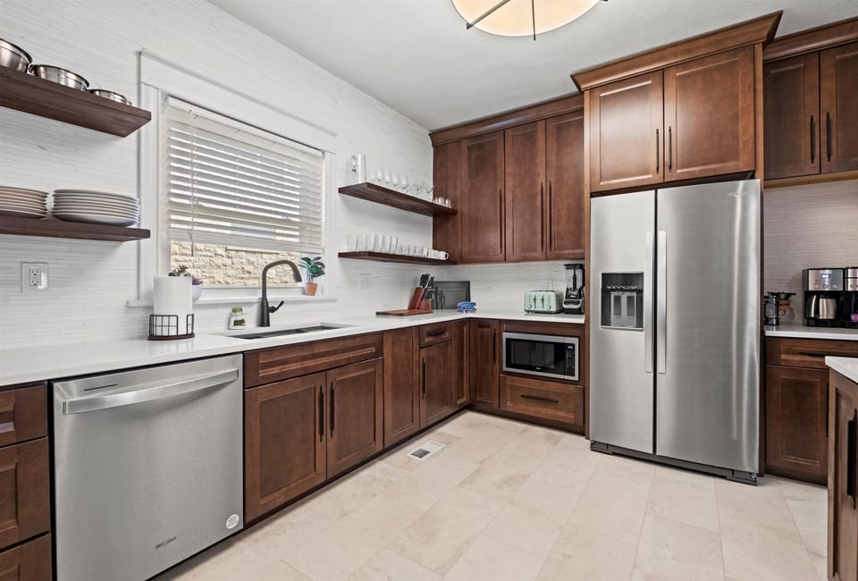 Spacious and beautifully designed kitchen with open shelving, full cookware set, and ample counter space for groups and long-term stays.