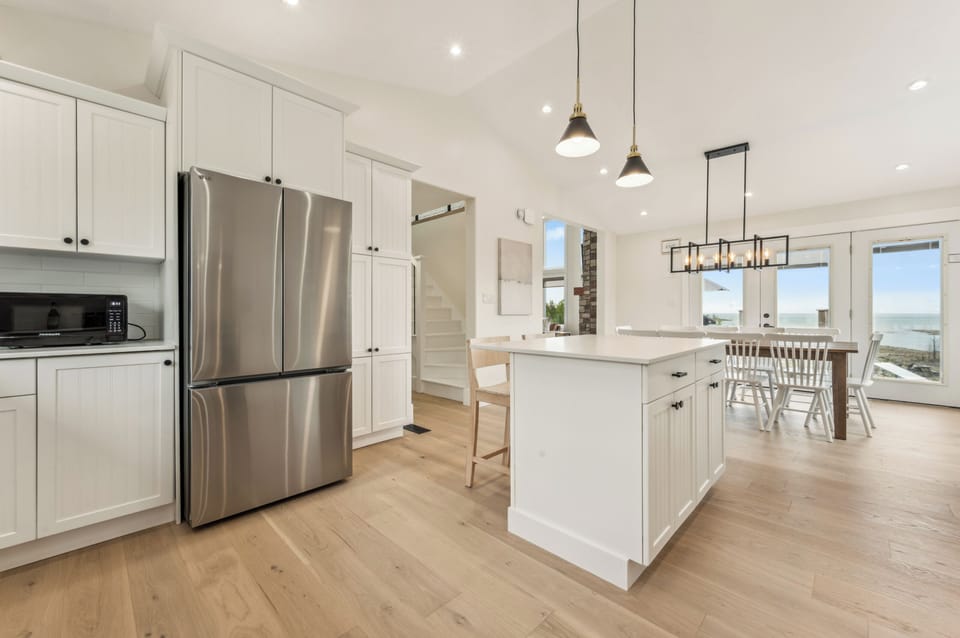 Entertain in a bright, fully stocked kitchen with high ceilings, modern fixtures, and large island seating—perfect for group meals.