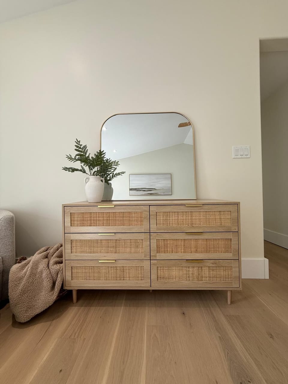 Thoughtful touches throughout—this rattan-accented dresser and curated design details create a tranquil atmosphere.
