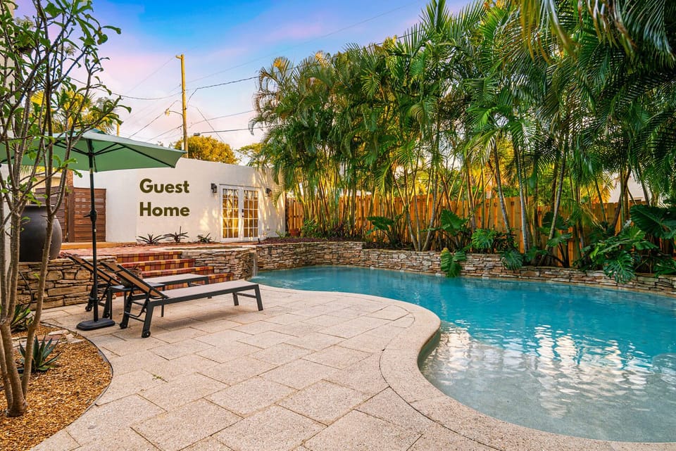 Enjoy a tropical backyard escape with a sparkling pool and a picnic area, perfect for outdoor fun.
