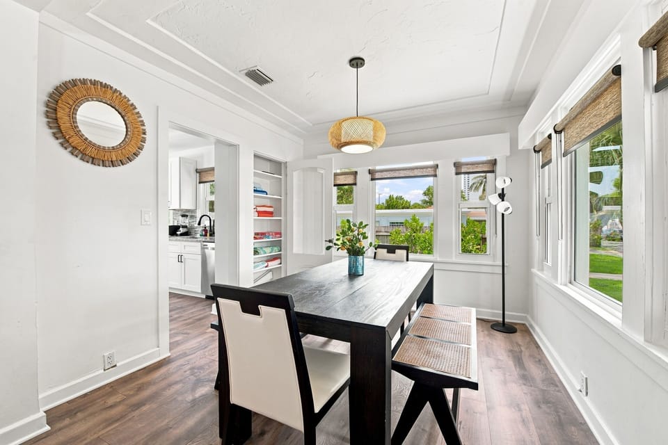 Sunlit dining nook featuring a rustic wood table and built-in linen storage.