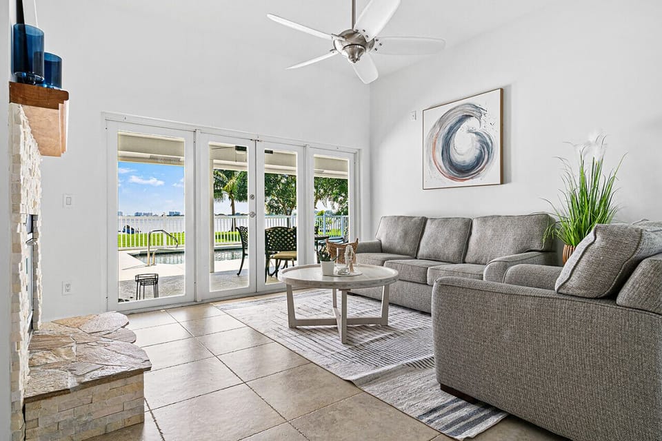 Inviting living room with high ceilings, comfortable sofas, and large windows showcasing beautiful outdoor scenery.